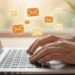 Person typing an email newsletter on a laptop, representing how to build an engaged email list through authentic communication